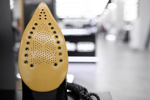 A new iron on a shelf in a large department of home appliances.