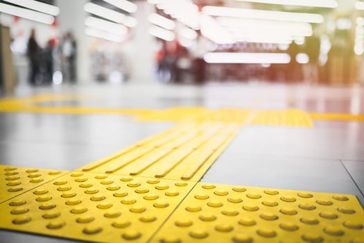 Yellow tactile pavement for the blind on the floor in the mall.