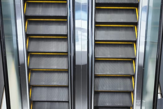 Top view on double escalator with opposite direction in the interior of a public building.