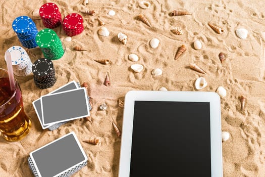 Online poker game on the beach with digital tablet and stacks of chips. Top view. Copy space. Flat lay