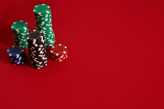 Poker chips on red background. Group of different poker chips. Casino background. Copy space. Still life