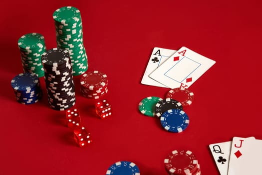 Poker chips and aces on red background. Group of different poker chips. Casino background. Copy space. Still life. One Pair