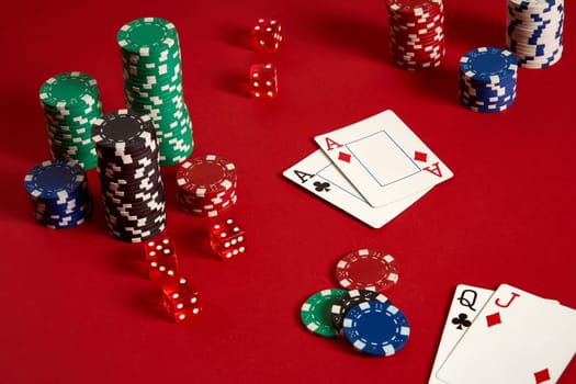 Poker chips and aces on red background. Group of different poker chips. Casino background. Copy space. Still life. One Pair