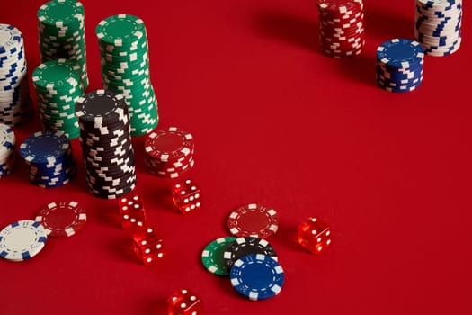 Poker chips on red background. Group of different poker chips. Casino background. Copy space. Still life