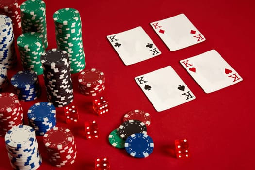 Casino gambling poker equipment and entertainment concept - close up of playing cards and chips at red background. Four of a Kind. Casino background. Copy space. Still life