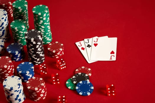 Casino gambling poker equipment and entertainment concept - close up of playing cards and chips at red background. Three of a Kind. Casino background. Copy space. Still life