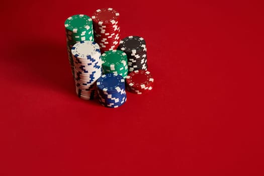 Poker chips on red background. Group of different poker chips. Casino background. Copy space. Still life