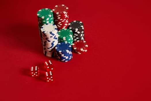 Poker chips on red background. Group of different poker chips. Casino background. Copy space. Still life