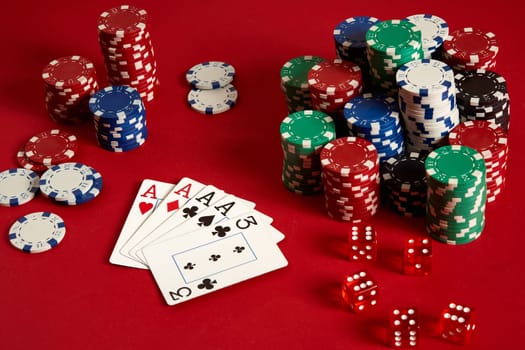 Casino gambling poker equipment and entertainment concept - close up of playing cards and chips at red background. Four of a Kind. Casino background. Copy space. Still life