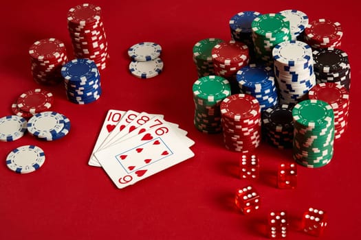 Casino gambling poker equipment and entertainment concept - close up of playing cards and chips at red background. Straight Flush. Casino background. Copy space. Still life