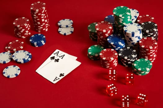 Poker chips and aces on red background. Group of different poker chips. Casino background. Copy space. Still life. One Pair