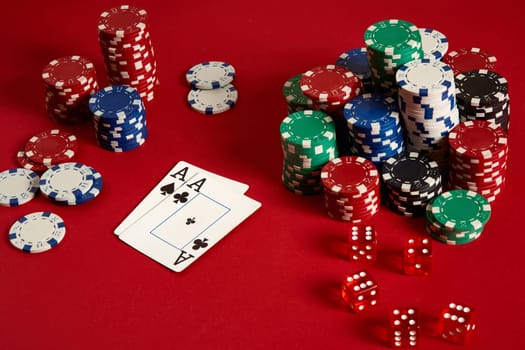 Poker chips and aces on red background. Group of different poker chips. Casino background. Copy space. Still life. One Pair