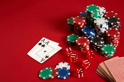 Poker chips and aces on red background. Group of different poker chips. Casino background. Copy space. Still life. One Pair