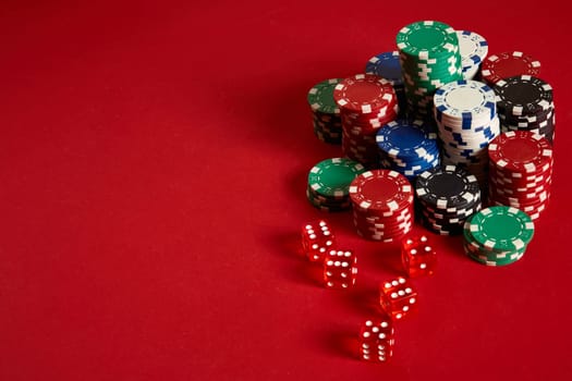Poker chips on red background. Group of different poker chips. Casino background. Copy space. Still life