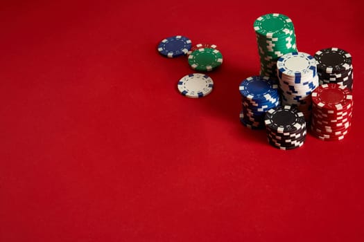 Poker chips on red background. Group of different poker chips. Casino background. Copy space. Still life