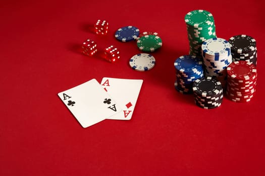 Poker chips and aces on red background. Group of different poker chips. Casino background. Copy space. Still life. One Pair
