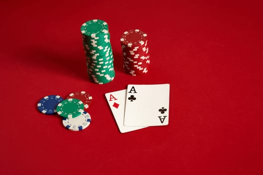 Poker chips and aces on red background. Group of different poker chips. Casino background. Copy space. Still life. One Pair