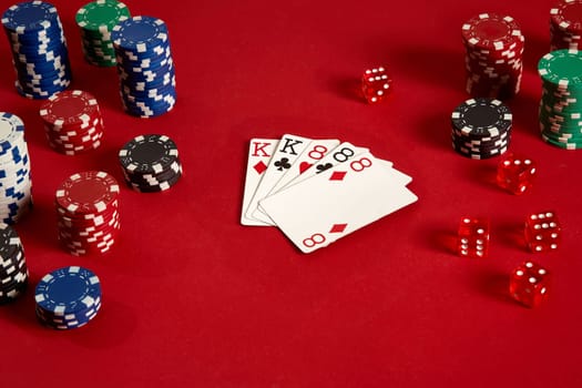 Poker cards and gambling chips on red background. Top view. Copy space. Still life. Flat lay. Full house