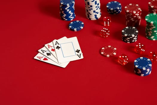 Casino gambling poker equipment and entertainment concept - close up of playing cards and chips at red background. Four of a Kind. Casino background. Copy space. Still life