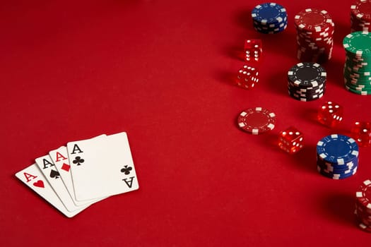 Poker cards and gambling chips on red background. Top view. Copy space. Still life. Flat lay. Cards - four aces. 4 of a kind