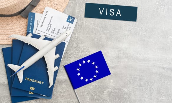 Flag of European Union with passport and toy airplane on wooden background. Flight travel concept.