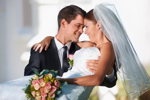 Wedding, marriage or carry with a bride and groom in celebration outdoor as a newlywed married couple. Smile, romance and tradition with a man carrying a woman over the threshold after a ceremony.