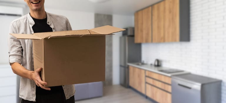 young man carries moving boxes.