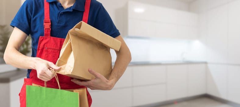 Young handsome man holding delivery paper bag.