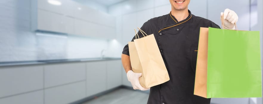 Young handsome man holding delivery paper bag.