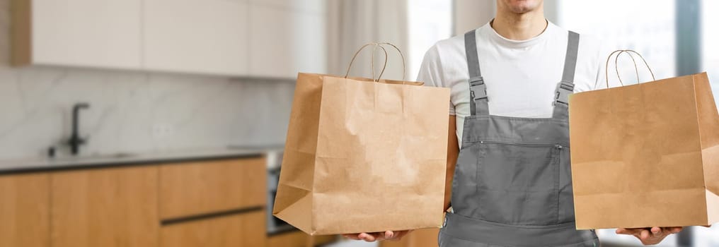 Young handsome man holding delivery paper bag.