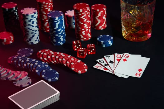 Cards of poker player. On the table are chips and a glass of cocktail with whiskey. Still life. The concept of gambling. Poker Online. Combination of cards