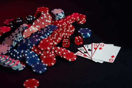 Casino chips and cards on black table surface. Gambling, fortune, game and entertainment concept - close up. Poker Online. Copy space. Ideal for advertisement. Still life