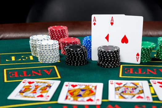 Poker play. Chips and cards on the green table