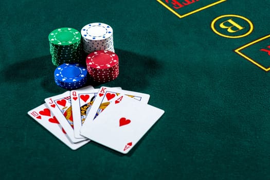 Poker play. Chips and cards on the green table