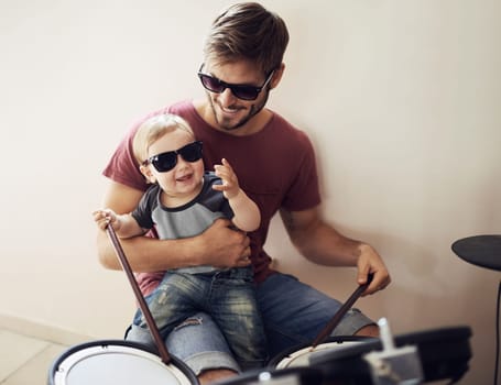 Father, baby and child drum lesson with music development and learning. Home, happiness and bonding with youth drumming teaching with a smile, love and happy parent care together at a family house.