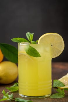 Lemonade with fresh mint leaves and lemon slice in glass glass on wooden table