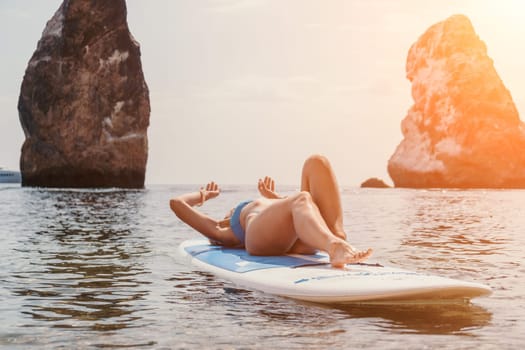 Close up shot of beautiful young caucasian woman with black hair and freckles looking at camera and smiling. Cute woman portrait in a pink bikini posing on a volcanic rock high above the sea