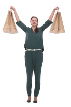 Smiling woman raising her shopping bags against a white background. Concept of happy shopping
