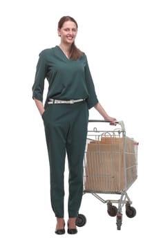 Full length portrait of a woman pushing a shopping trolley isolated on white background