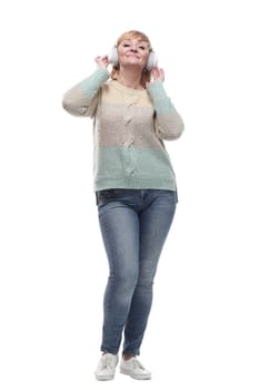 in full growth. attractive casual woman listening to music through headphones. isolated on a white