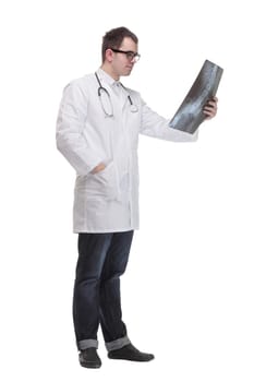 Front view of hospital doctor holding patient's x-ray film and lookind at it
