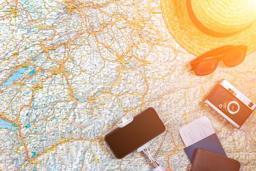 Accessories for travel. Passport, photo camera, smart phone and travel map. Top view. Holidays and tourism concept. Copy space. Still life. Flat lay. Sun flare