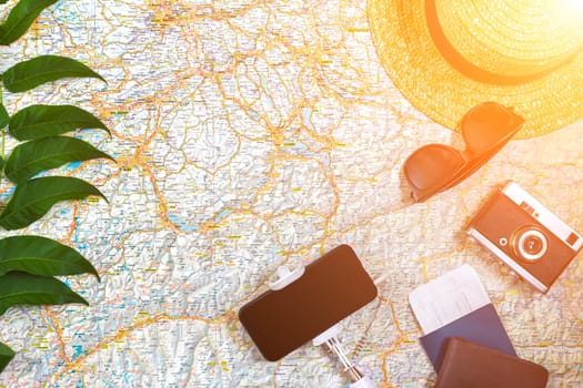 Accessories for travel. Passport, photo camera, smart phone and travel map. Top view. Holidays and tourism concept. Copy space. Still life. Flat lay. Sun flare