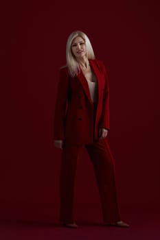 Portrait of a blonde woman in red dress on a red background