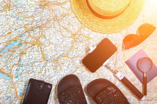 Accessories for travel. Passport, hat, smart phone and travel map. Top view. Holidays and tourism concept. Copy space. Still life. Flat lay. Sun flare