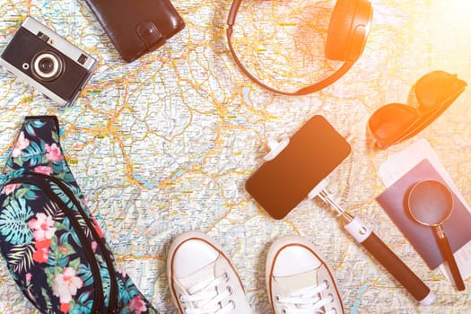 Accessories for travel. Passport, hat, smart phone and travel map. Top view. Holidays and tourism concept. Copy space. Still life. Flat lay. Sun flare