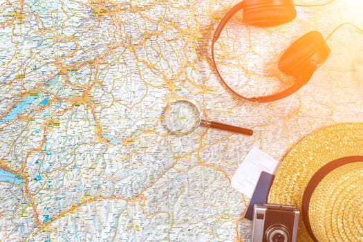 Accessories for travel. Passport, photo camera, smart phone and travel map. Top view. Holidays and tourism concept. Copy space. Still life. Flat lay. Sun flare