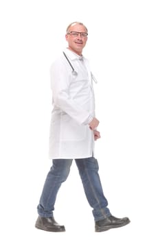Middle age male doctor walking away and look at camera isolated on white. Concept of health care
