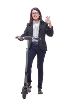 Happy beautiful woman standing near kick scooter and smiling at camera