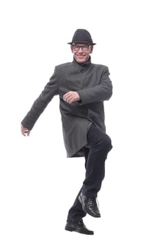 cheerful man in a hat and autumn coat striding forward . isolated on a white background